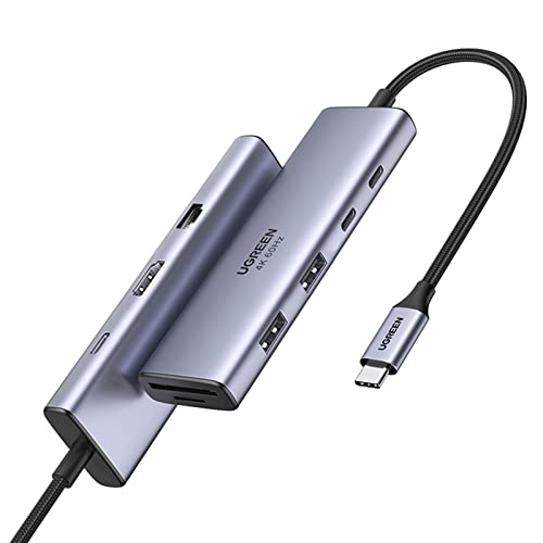 A UGREEN Revodok 9 in 1 USB C hub featuring a Gigabit Ethernet adapter, 4K HDMI output at 60Hz, 100W power delivery charging, multiple USB A and C data ports, and an SD/TF card reader, designed for compatibility with Mac M1, M2, M3, iPad, iPhone 16 Pro and Pro Max, and Steam Deck.